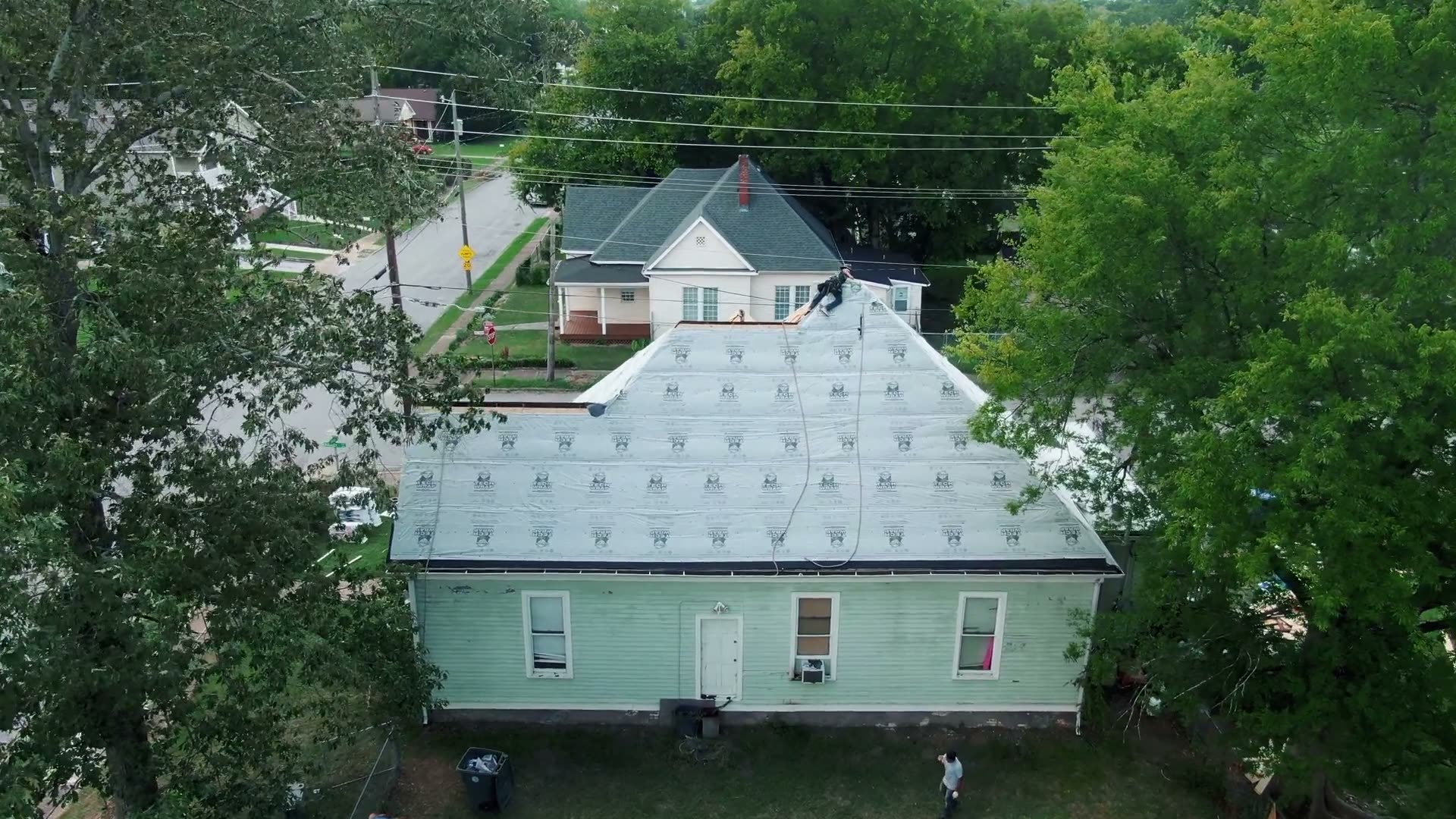 Roofing crew installing underlayment during a roof replacement